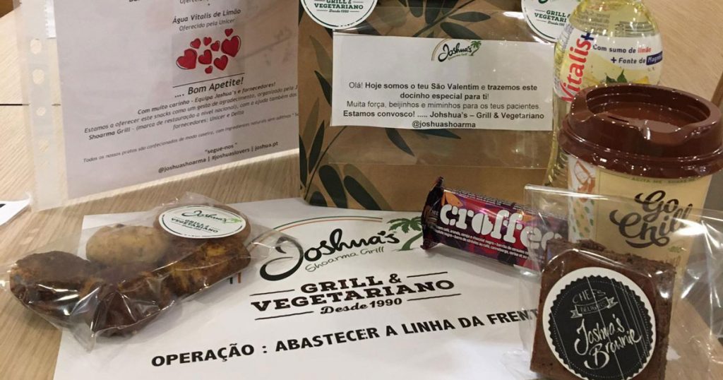 Na sequência da crise pandémica que estamos a atravessar, e de forma a oferecer o seu suporte aos profissionais de saúde que estão na linha da frente, a Joshua’s Shoarma, cadeia portuguesa de restauração de duplo conceito de Grill & Vegetariano, criou o programa “Operação: Abastecer a linha da frente” para distribuir refeições completas e saudáveis nos hospitais Amadora Sintra e Santa Maria. Com 36 lojas de norte a sul de Portugal, a ideia será alargar a operação para o resto do país. “Esta crise não nos deixa indiferentes nem insensíveis às dificuldades que os profissionais da linha da frente vivem diariamente, e o mínimo que podemos fazer é tentar trazer algum conforto e ajuda a estes profissionais”, explica Janette Mor, CEO da Joshua’s Shoarma Grill & Vegetariano. Foi a partir deste pensamento que nasceu a “Operação: Abastecer a linha da frente”, em que a cadeia de restaurantes distribui refeições quentes e saudáveis, e bebidas aos hospitais referidos, com a entrega, para cada profissional, de 1 sopa e 1 menu Joshua’s Real Meal que inclui um Pita Frango Burguer, batatas fritas, molho d’alho, uma limonada e, para sobremesa, um brownie (sem gluten). Existe ainda a opção de coxa de frango, arroz, salada de couve e apple crumble. As refeições da Joshua’s Shoarma Grill & Vegetariano são 100% de fabrico próprio e preparação artesanal. Durante a “Operação: Abastecer a linha da frente”, todas elas são enviadas com uma mensagem única e pessoal criada pelos colaboradores da cadeia de restaurantes, que visa encorajar e dar força a estes profissionais.